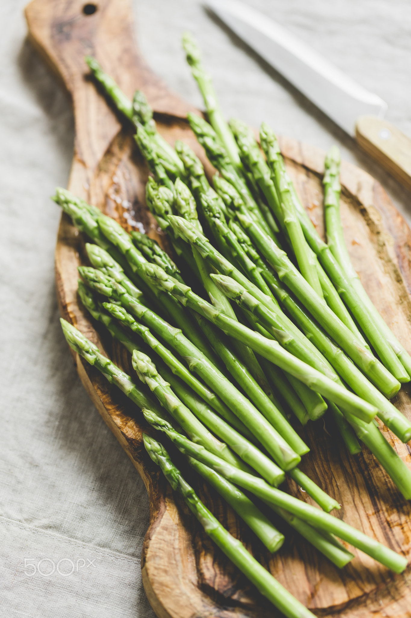 Fresh asparagus on a wooden cutting board. Preparation vegetarian healthy food.