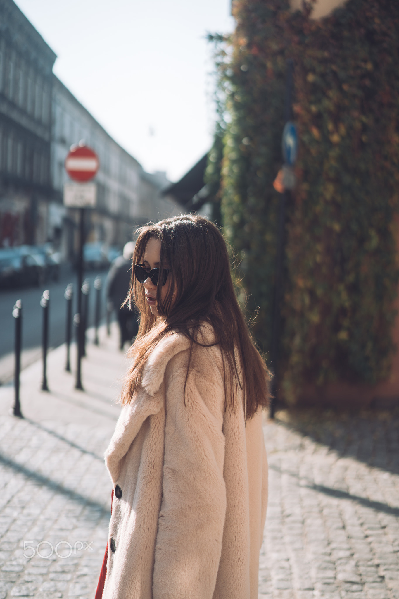 young beautiful stylish woman walking in pink coat
