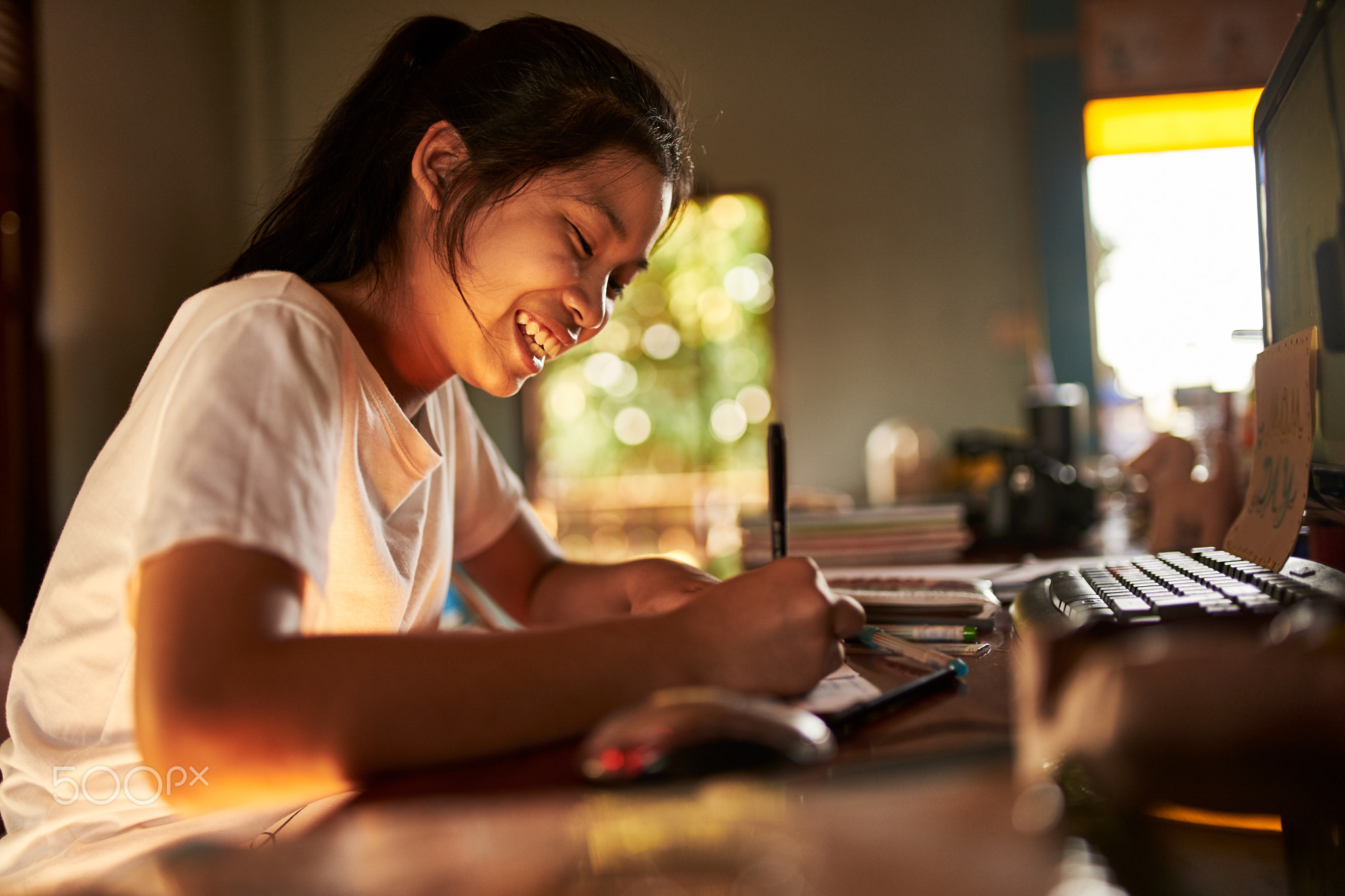 thai teen girl doing homework and studying at home