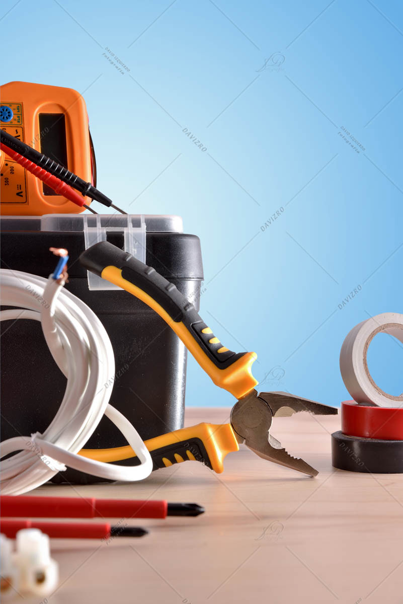 Electricity tools on wooden table with blue background vertical