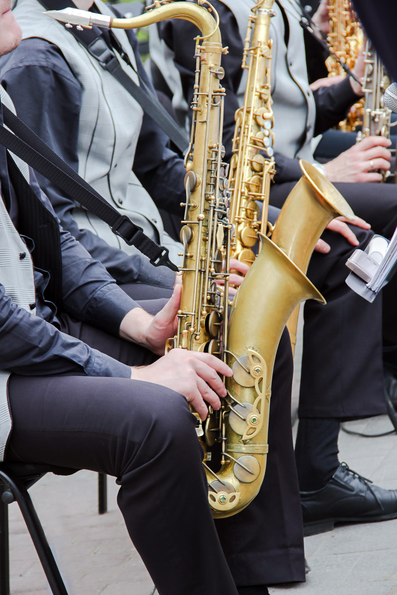 Saxophonists playing in a jazz band, dressed in men's classic vest and trousers