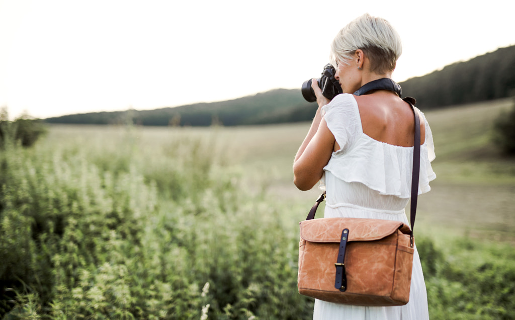 A rear view of woman with camera in nature, taking photographs. Copy space. by Jozef Polc on 500px.com