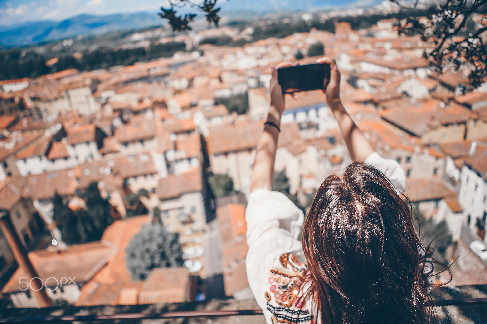 Young caucasian woman making photo by mobile phone from the observation place