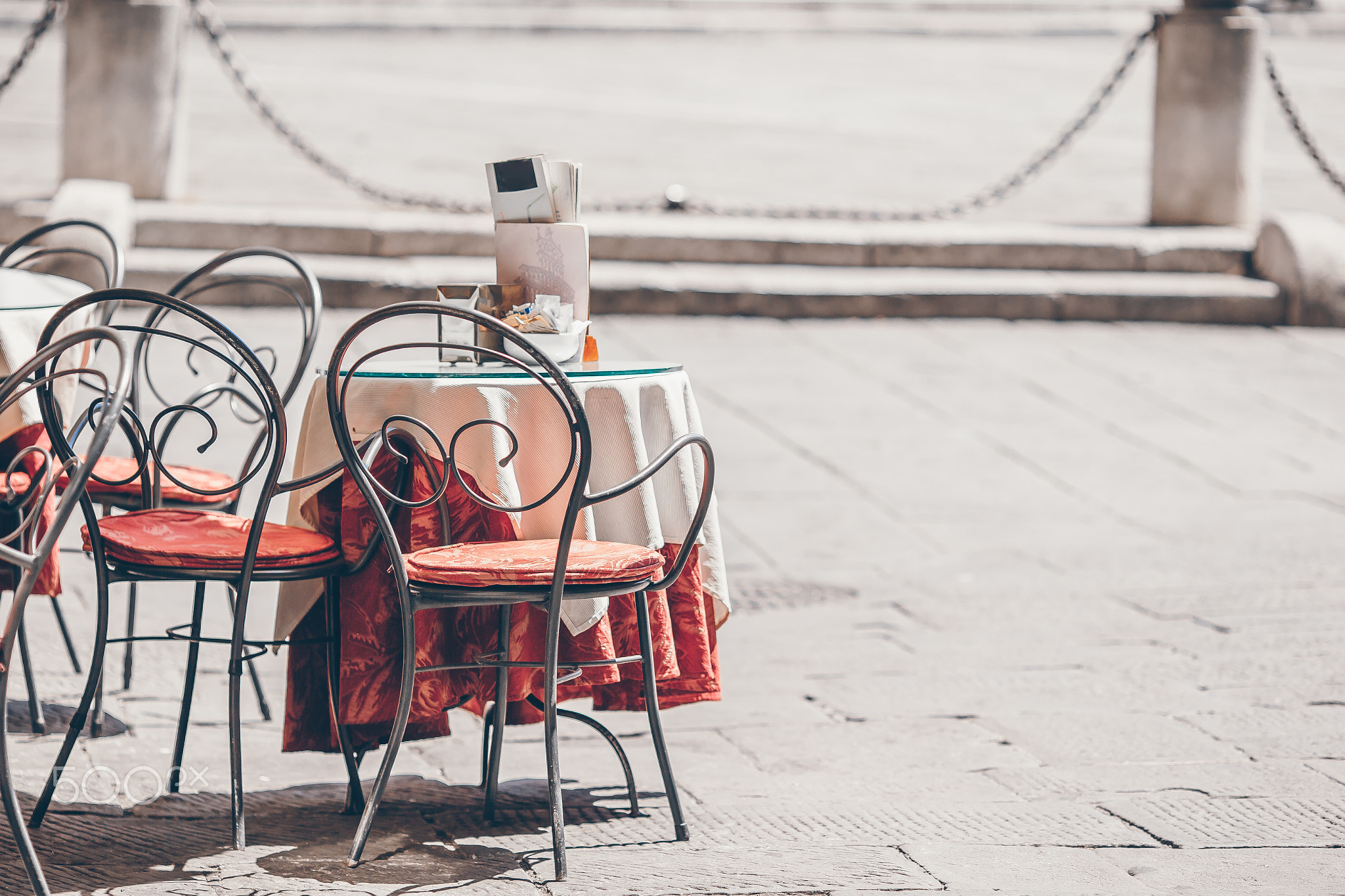 Summer empty open air restaraunt in Vatican city in Italy. Closeup wineglasses on the table