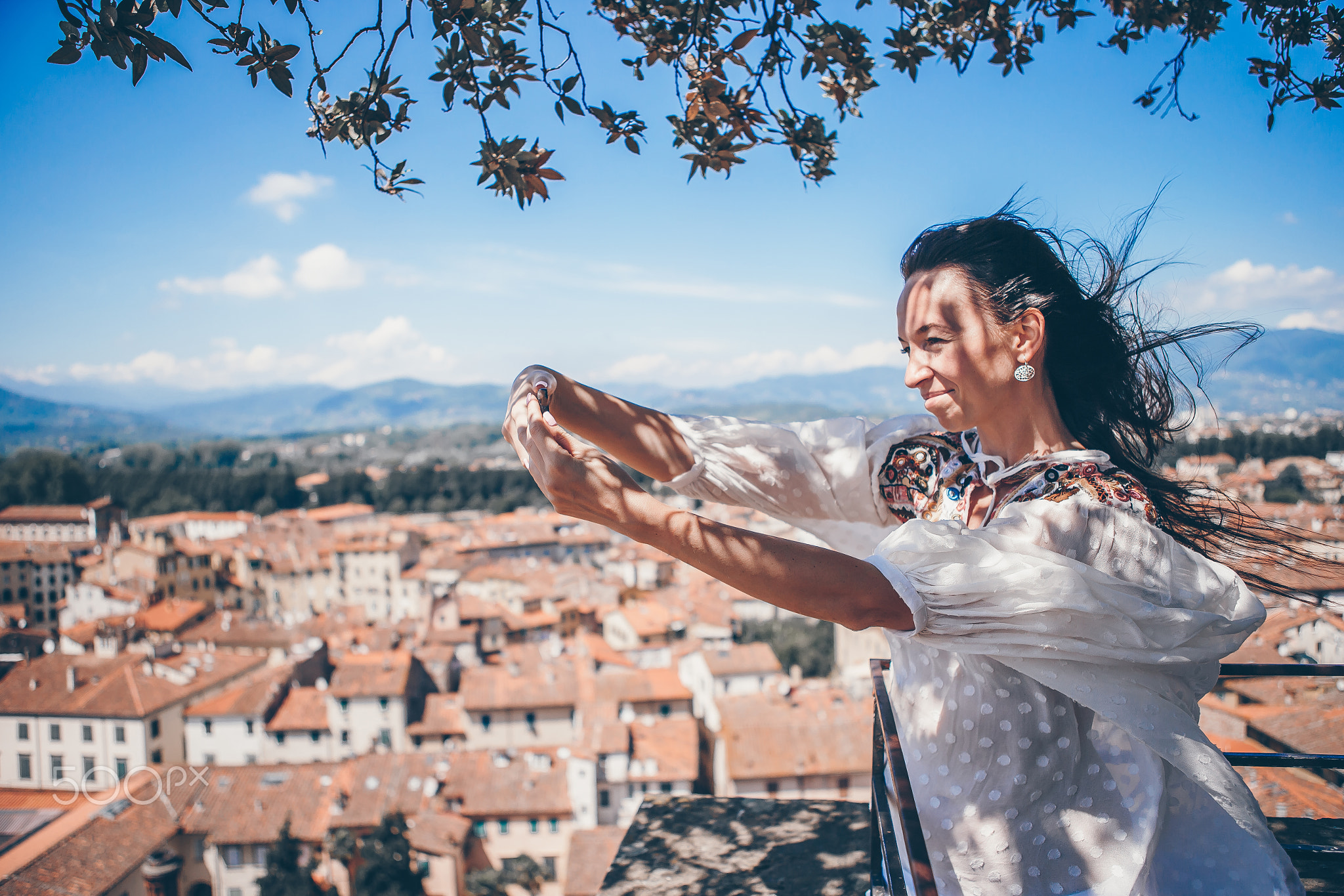 Young caucasian woman making photo by mobile phone from the observation place