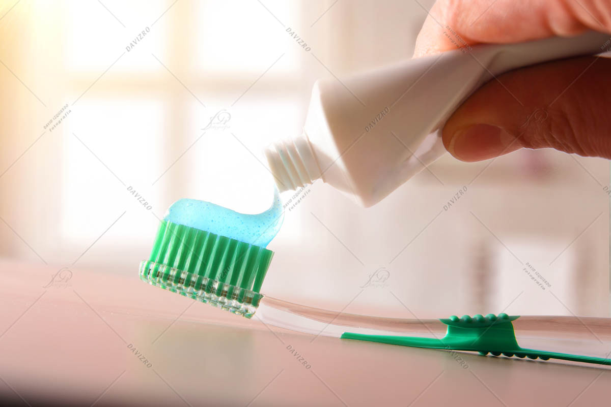 Concept oral hygiene with hand putting toothpaste on toothbrush