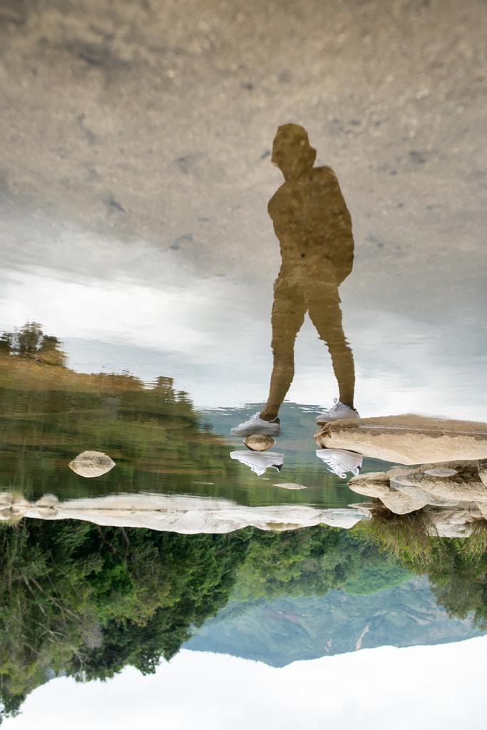 Invisible man in white sneakers reflected on water surface by Andrey Bezuglov on 500px.com