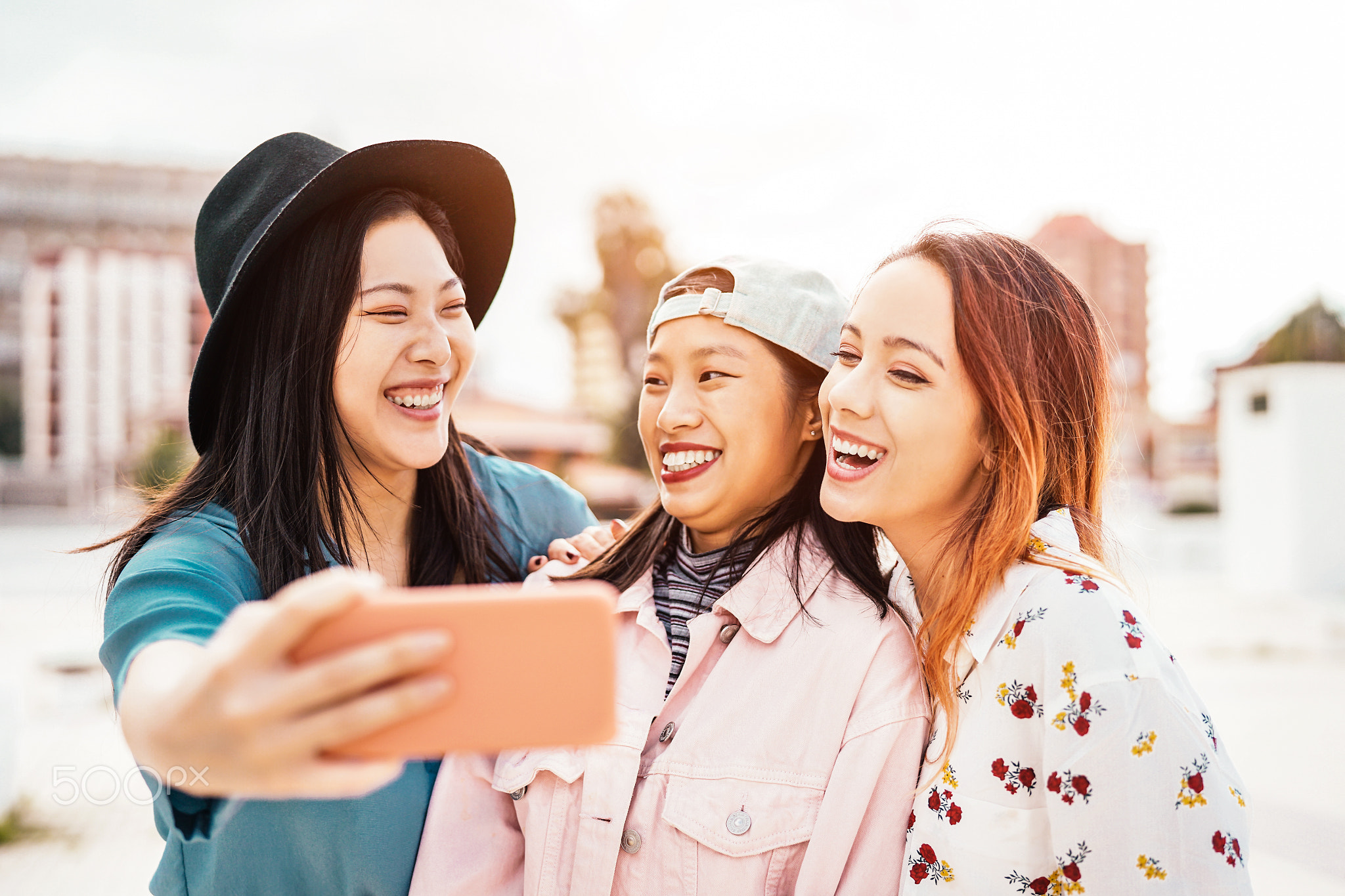 Happy Asian girls taking selfie with mobile smartphone outdoor