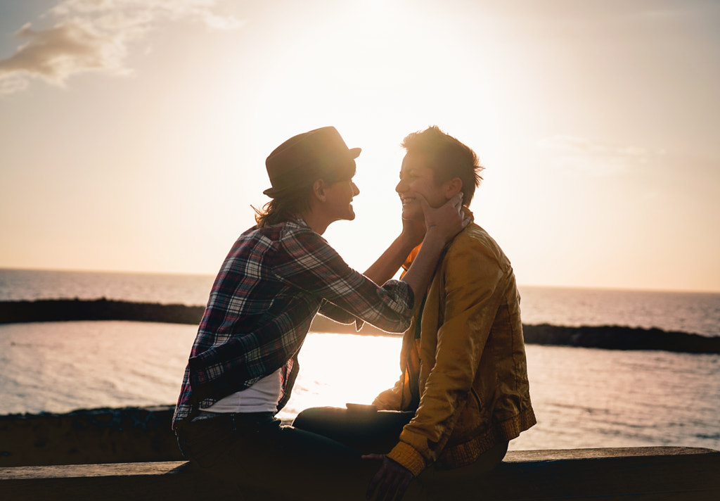 Happy gay couple dating next the beach at sunset by Alessandro Biascioli on 500px.com