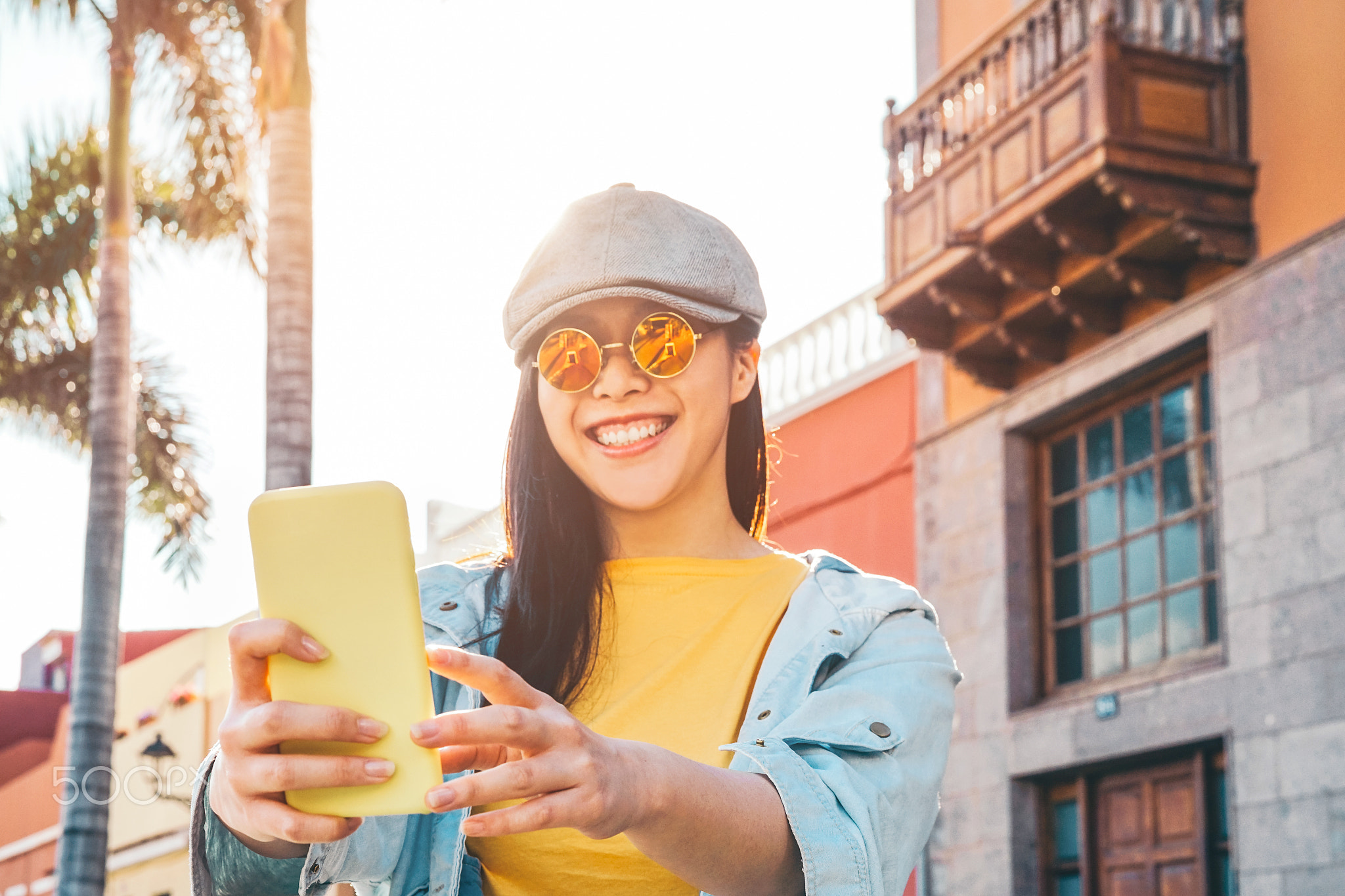 Happy Asian girl using mobile smartphone outdoor