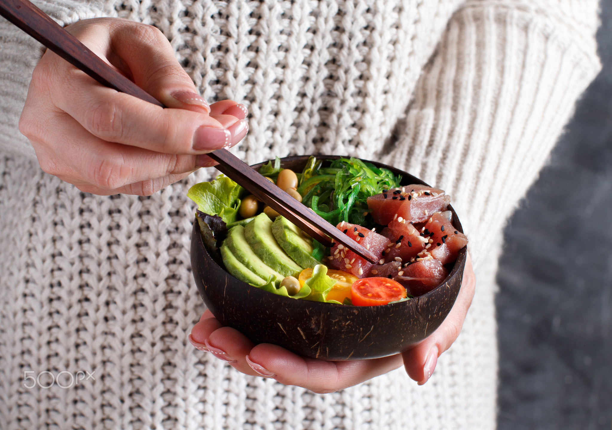 gGirl eating hawaiian tuna poke salad in the bowl