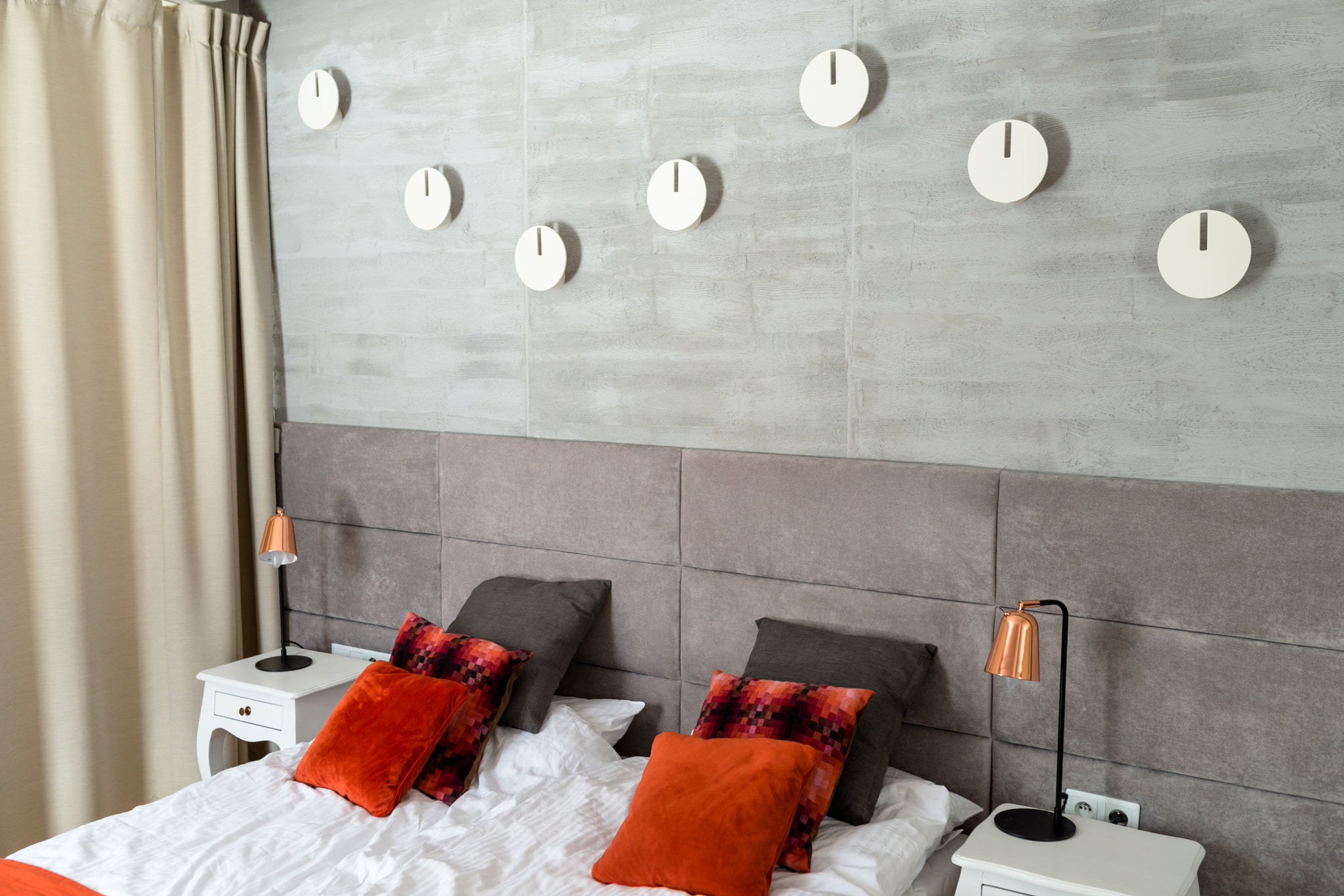 Bedroom with a large bed, orange pillows arranged