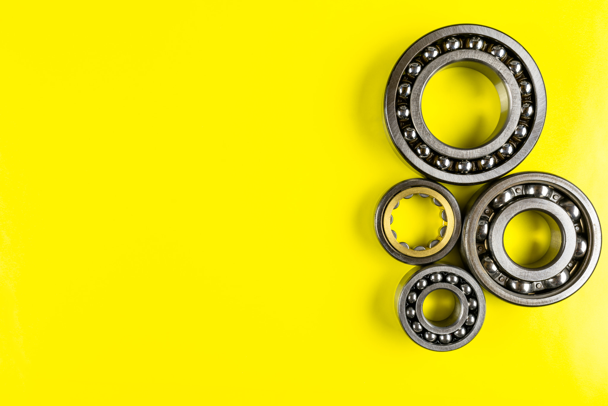 Ball bearing lying on a yellow background with cop