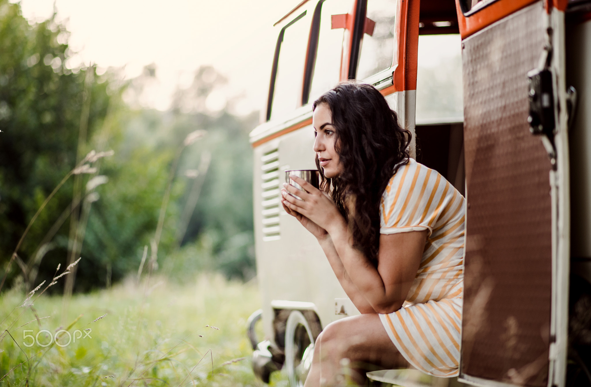 A young girl sitting in a car on a roadtrip through countryside.