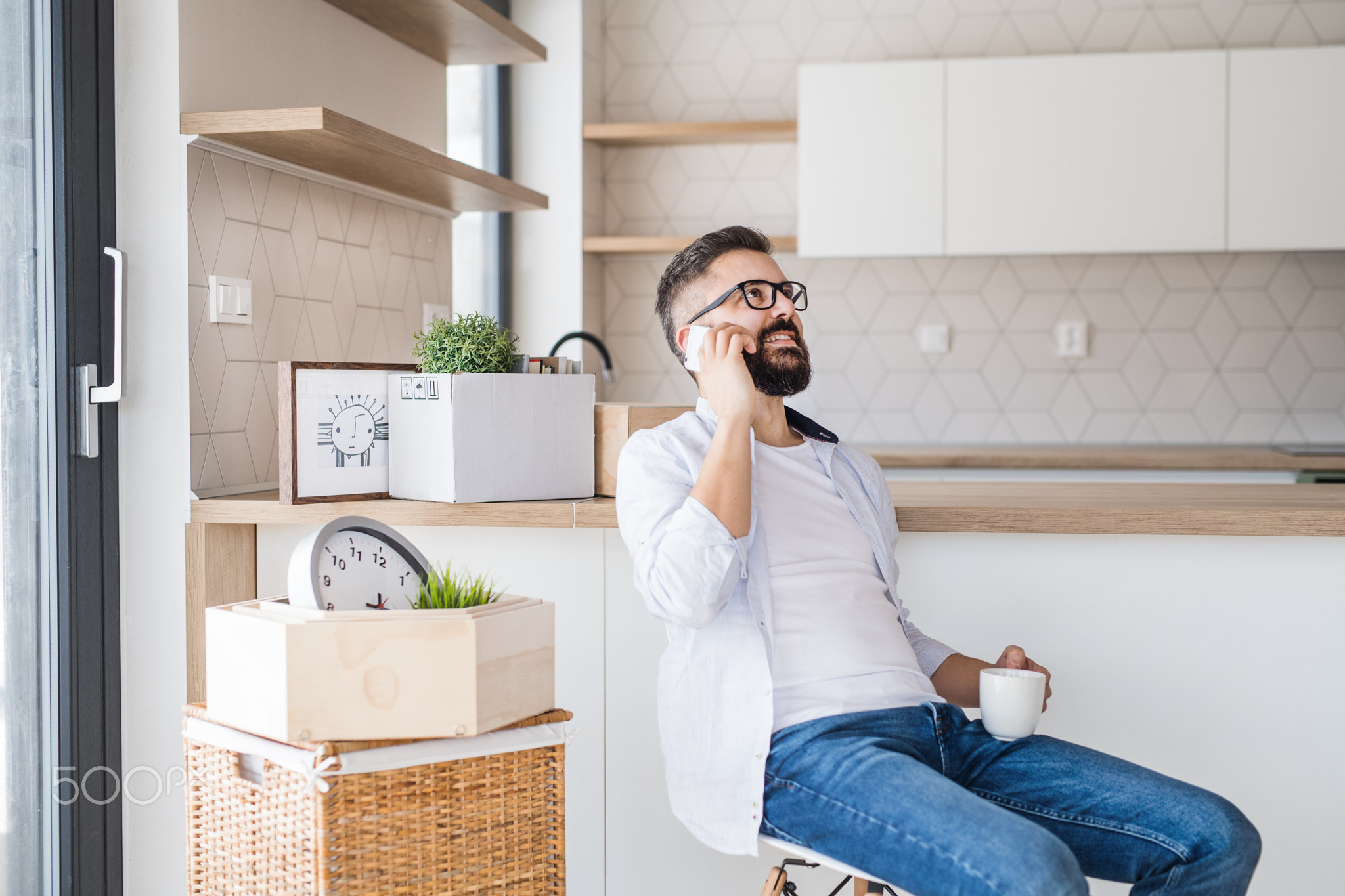 A mature man with smartphone moving in new home, making a phone call.