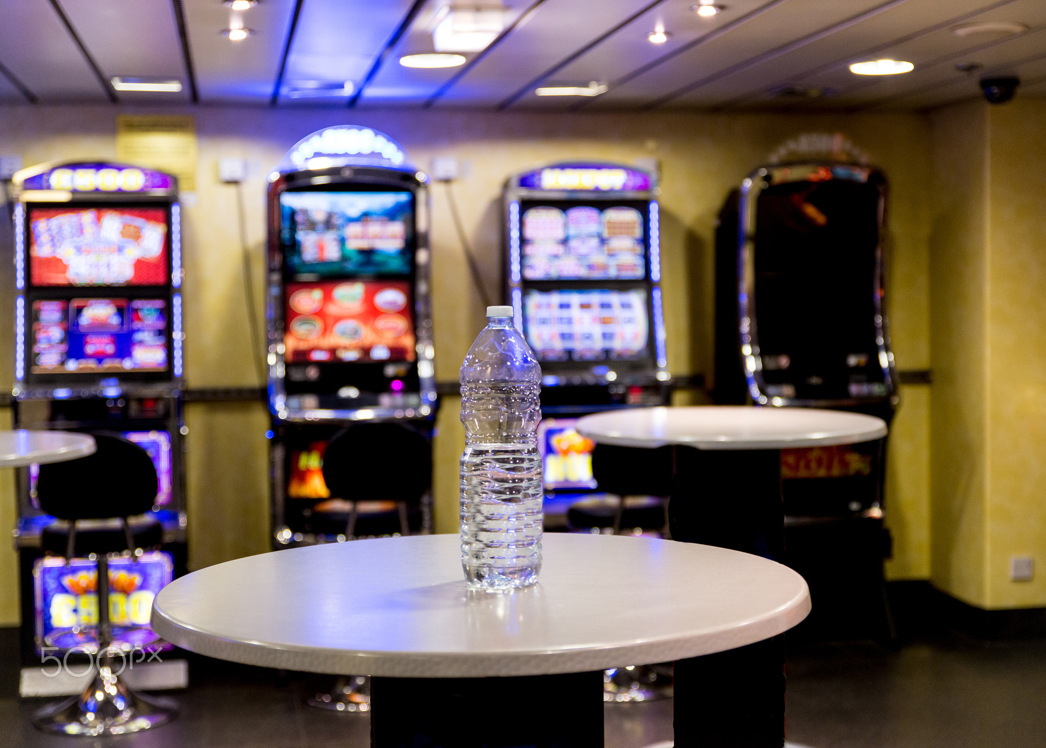 An empty water bottle on a table in a slot machine room