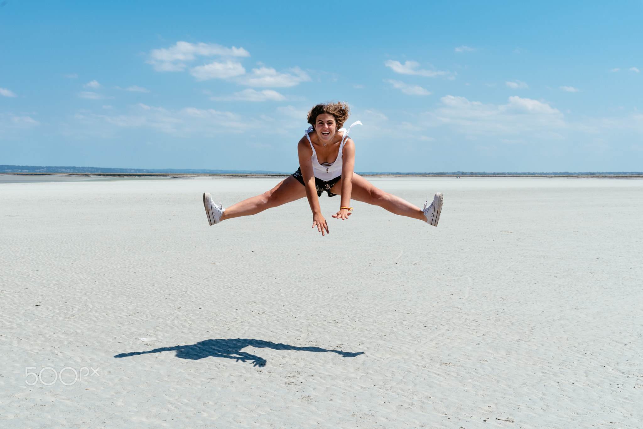 Portrait of female traveler jumping on the beach