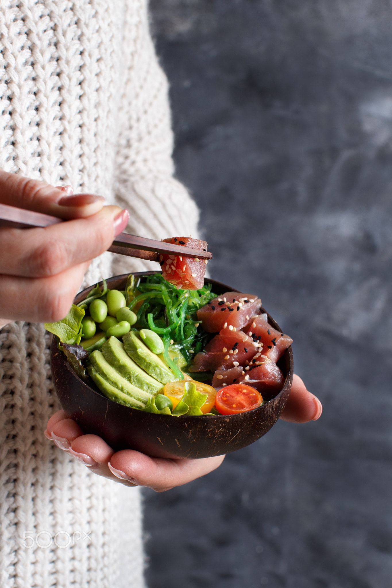 Girl eating hawaiian tuna poke salad in the bowl