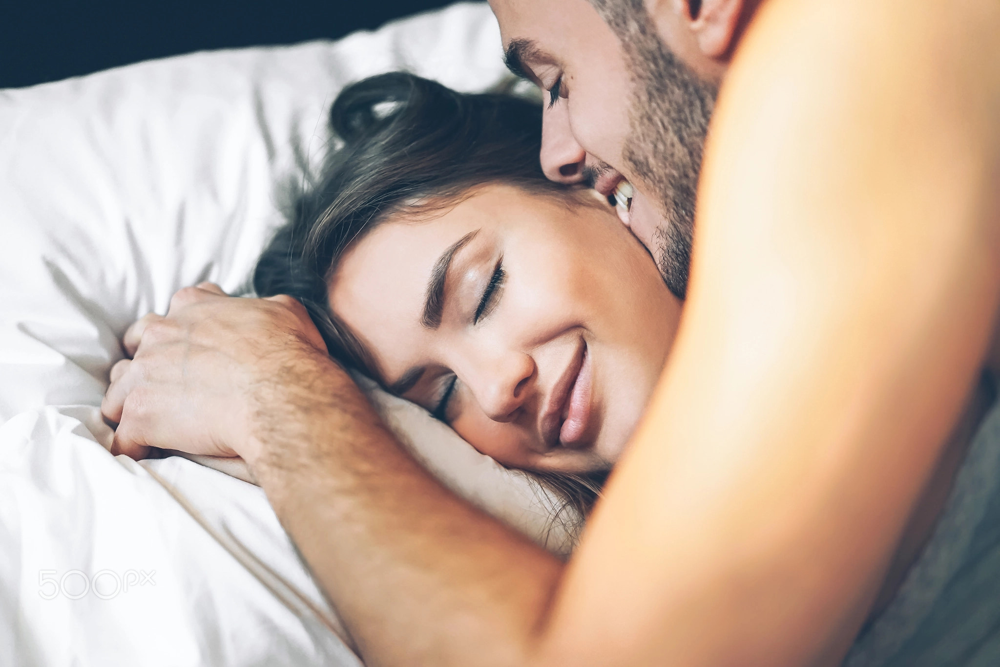 Happy romantic couple having a tender moment in the bed