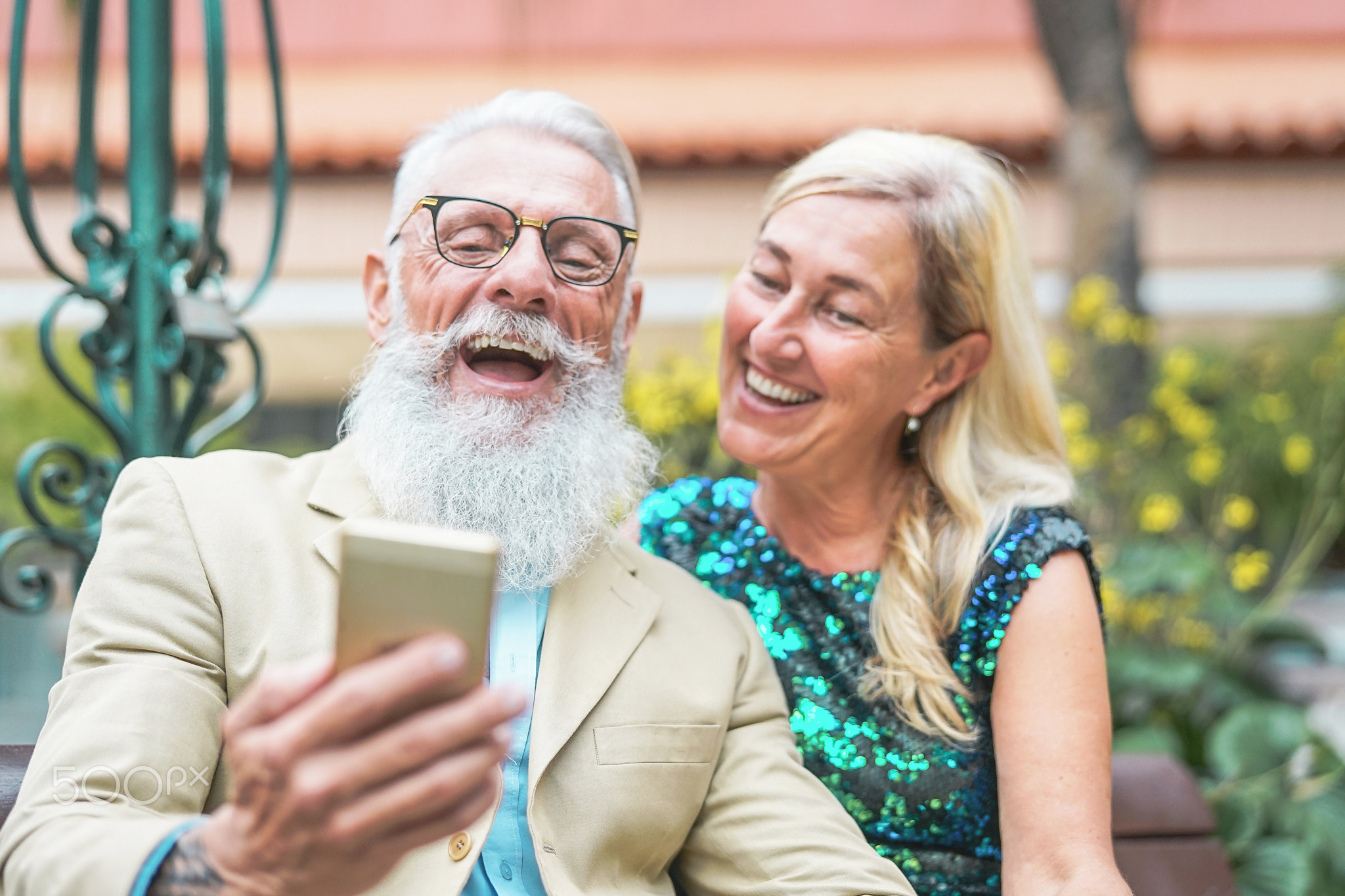 Happy senior couple watching on mobile smart phone