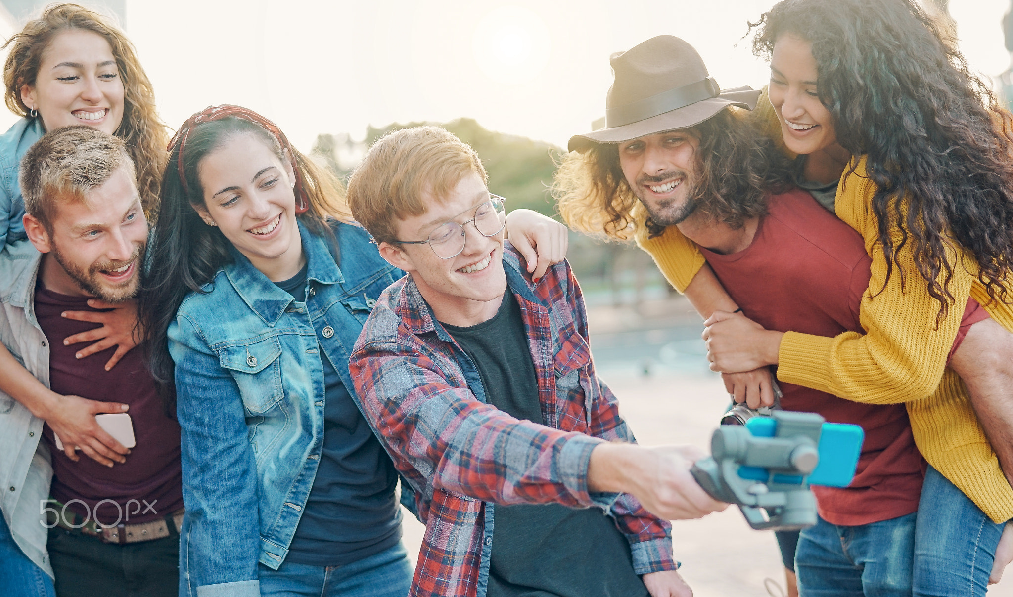 Happy trendy friends making video with gimbal smartphone camera