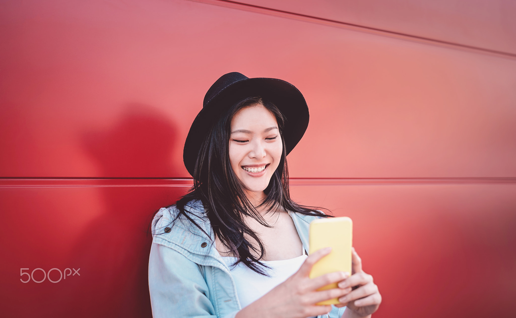 Happy Chinese girl using mobile phone outdoor