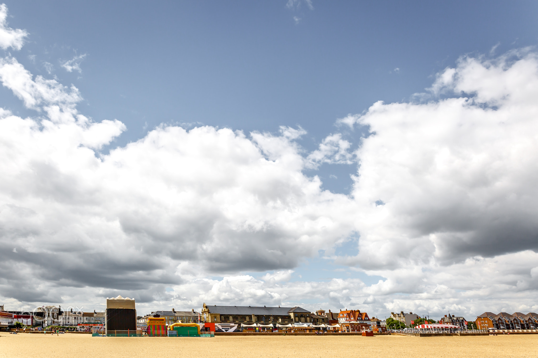 Scenic view of a beach with the city in the background on a sunn