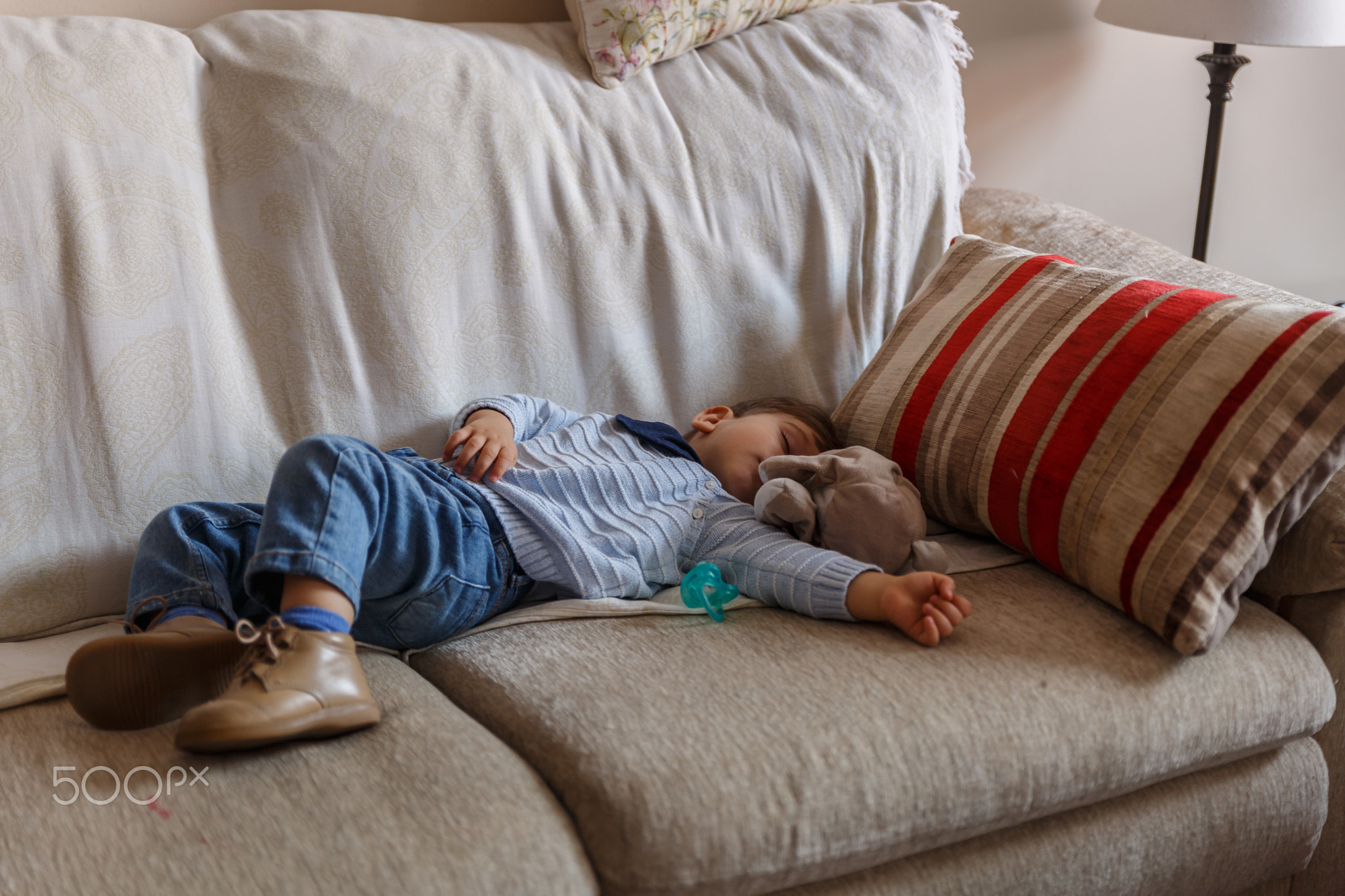 Cute boy rests peacefully on sofa in the living room of his hous