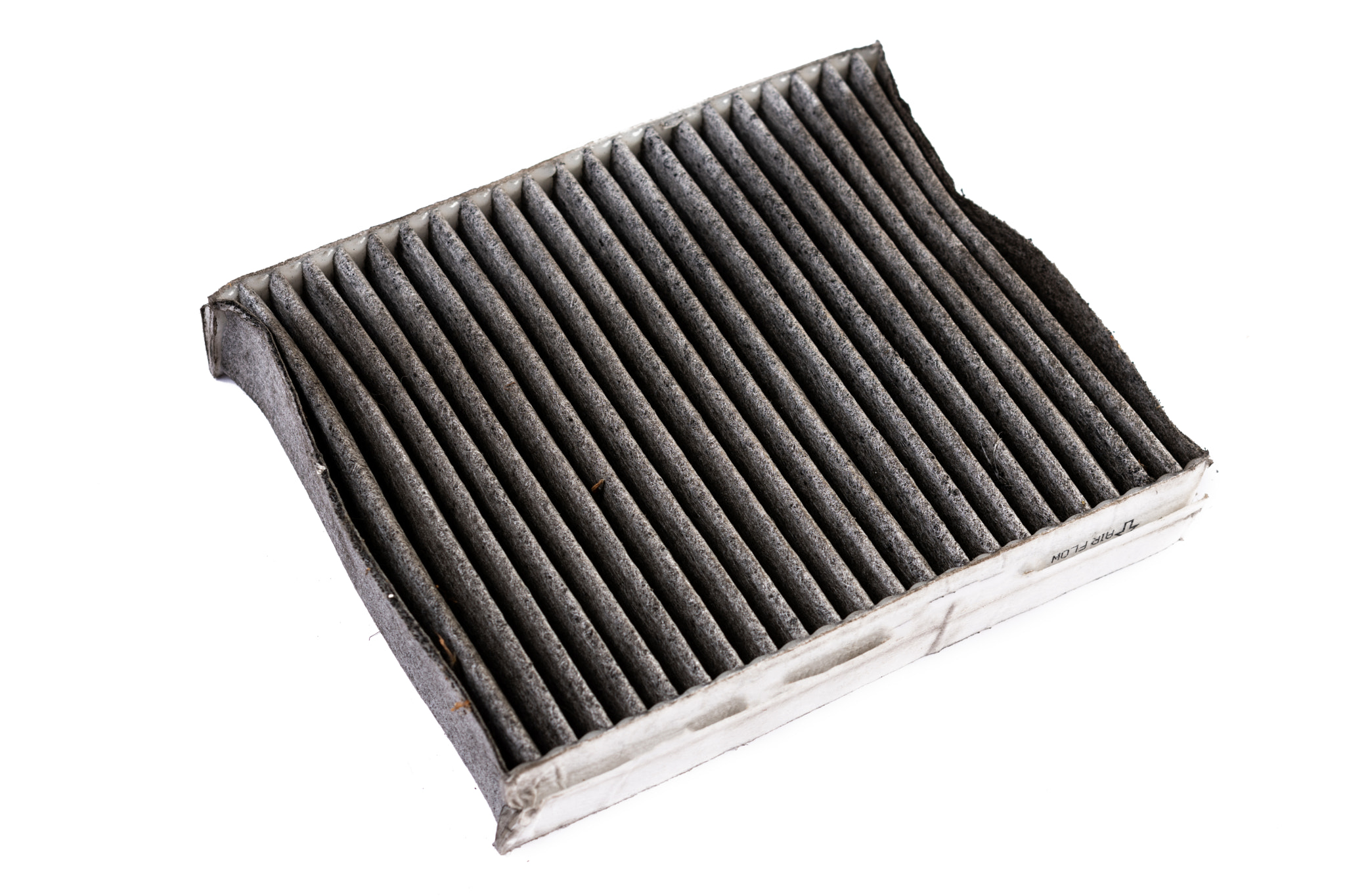 Dirty used car air conditioner filter isolated above white background.