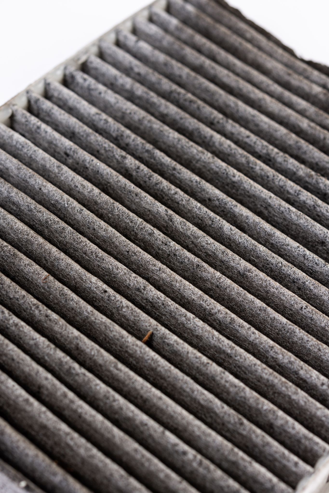 Dirty used car air conditioner filter isolated above white background.