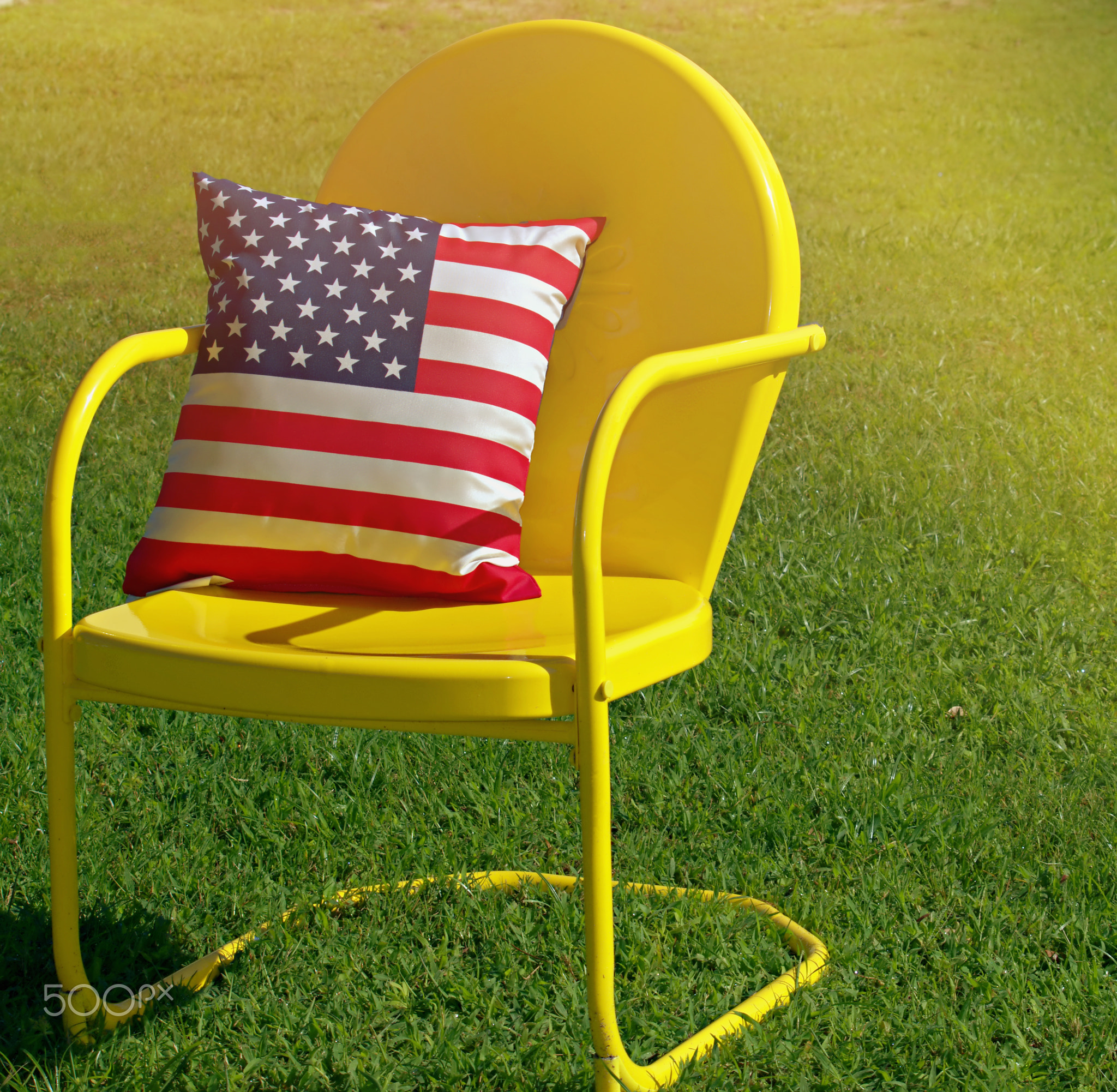 American Flag Pillow Sitting In A Yellow Chair