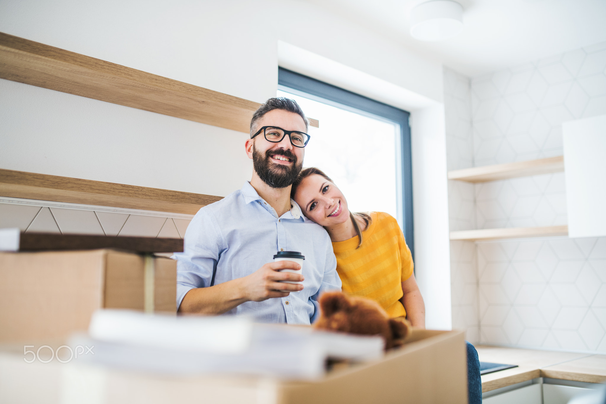 A young couple drinking coffee when moving in new home.