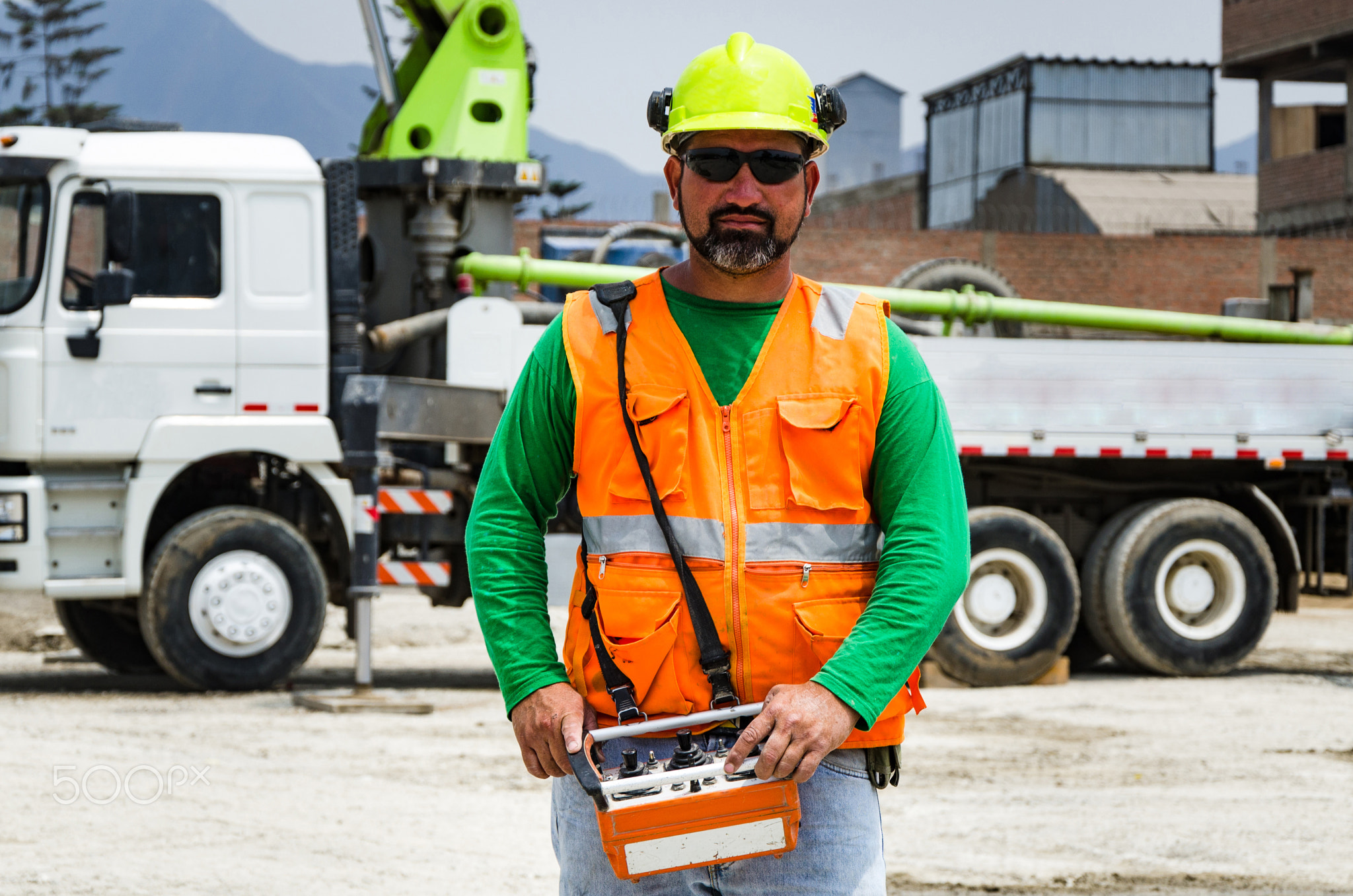 Concrete pump operator with remote control for boom pump truck at construction site