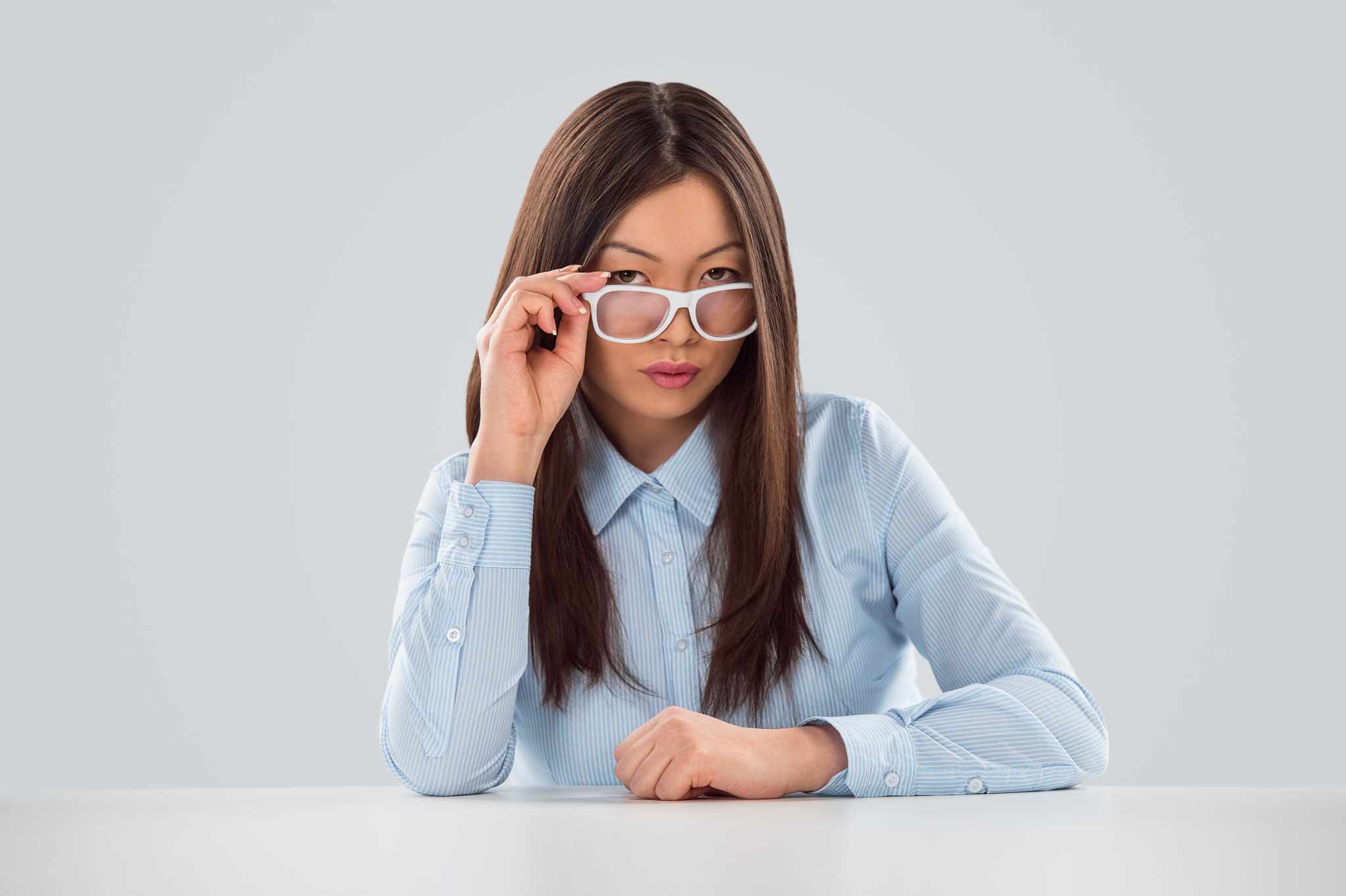 Sexy fashionable asian business woman sitting alone at office