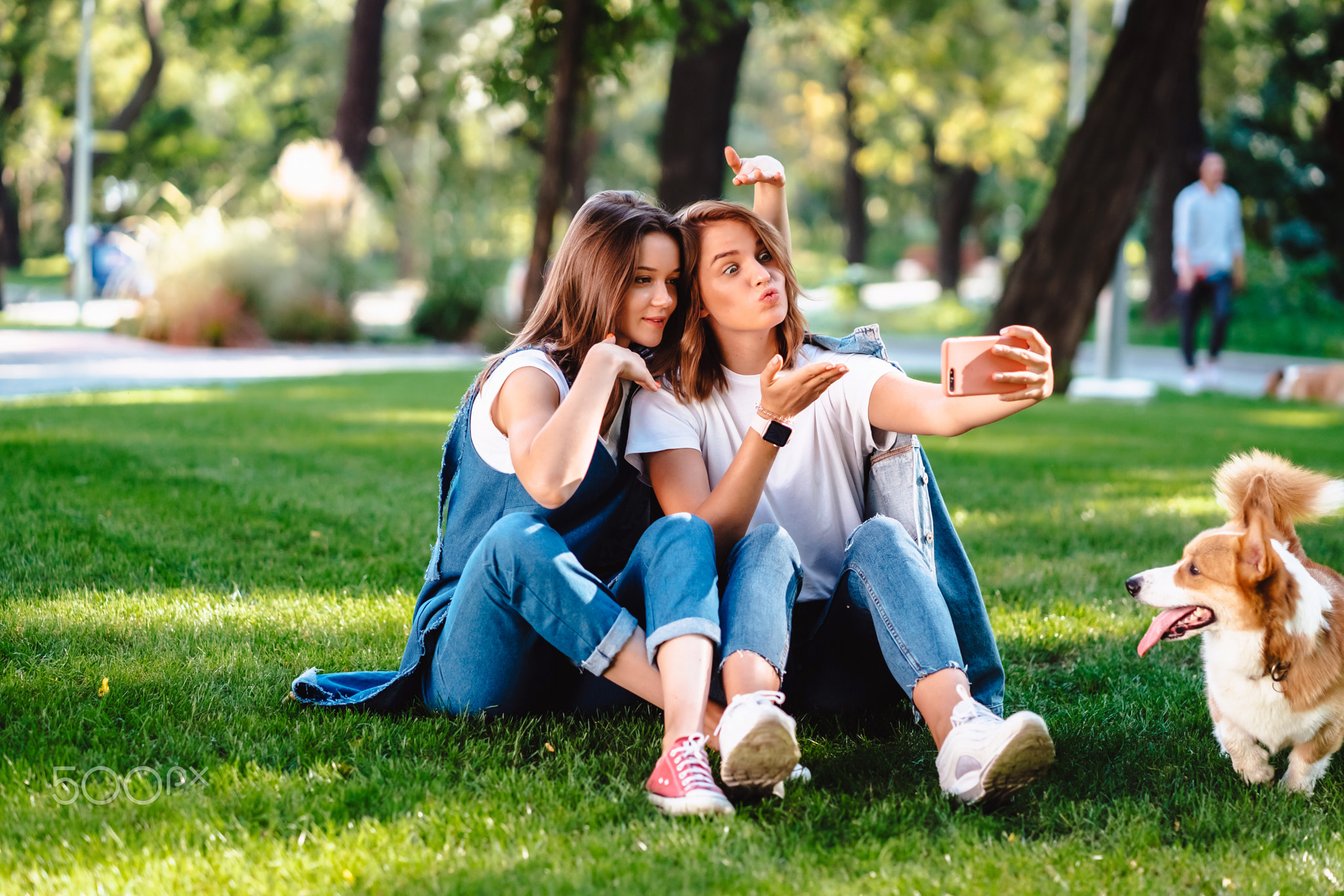 Two female friend sitting in the park have a rest take a selfie