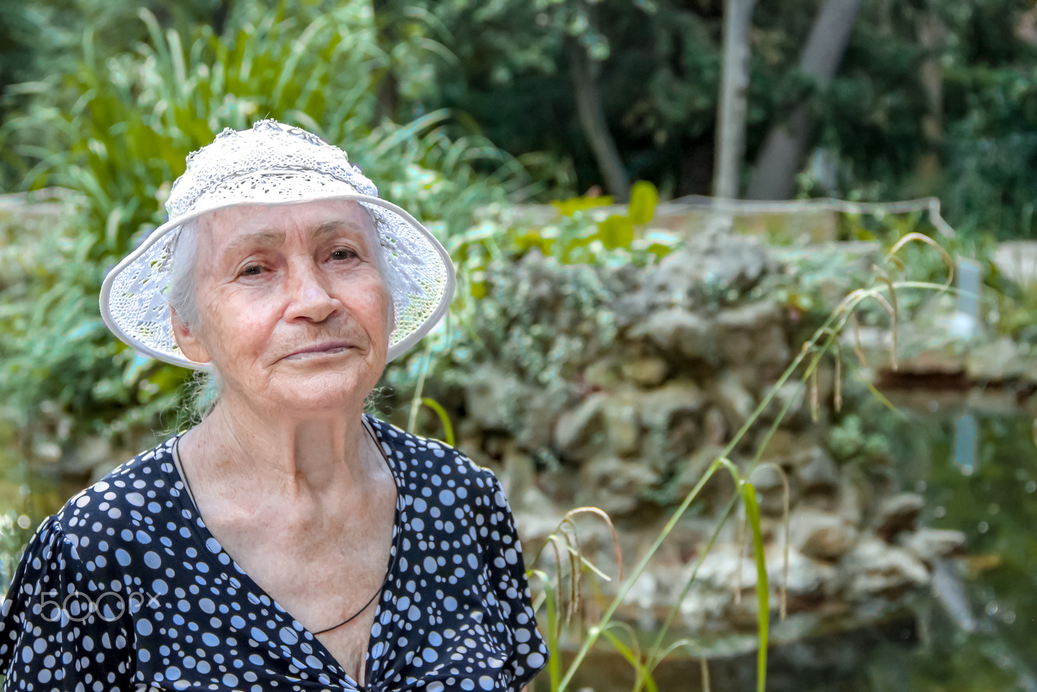 Close up portrait of older woman standing outside in summer