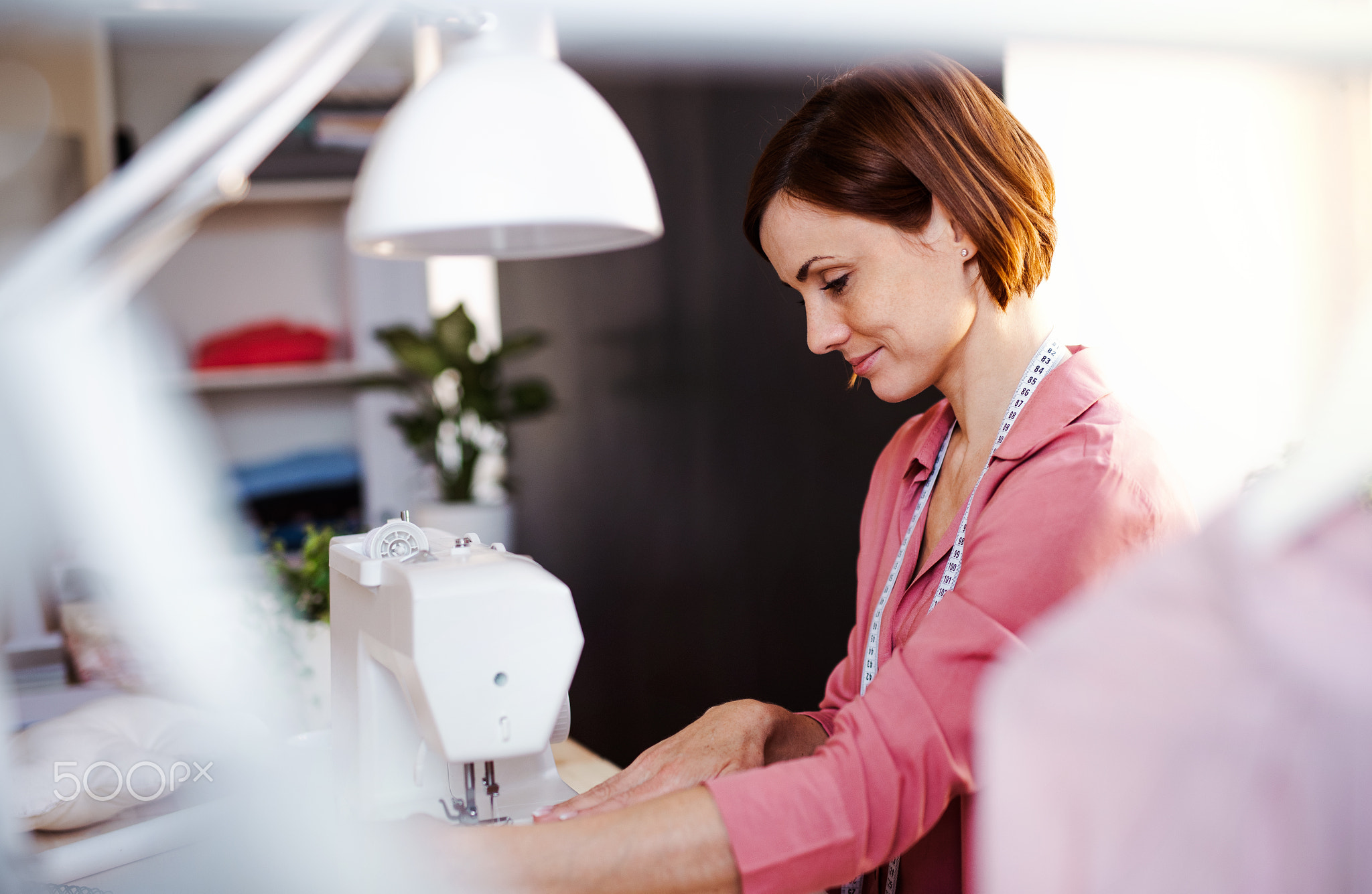 Young creative woman in a studio, working. A startup of tailoring business.