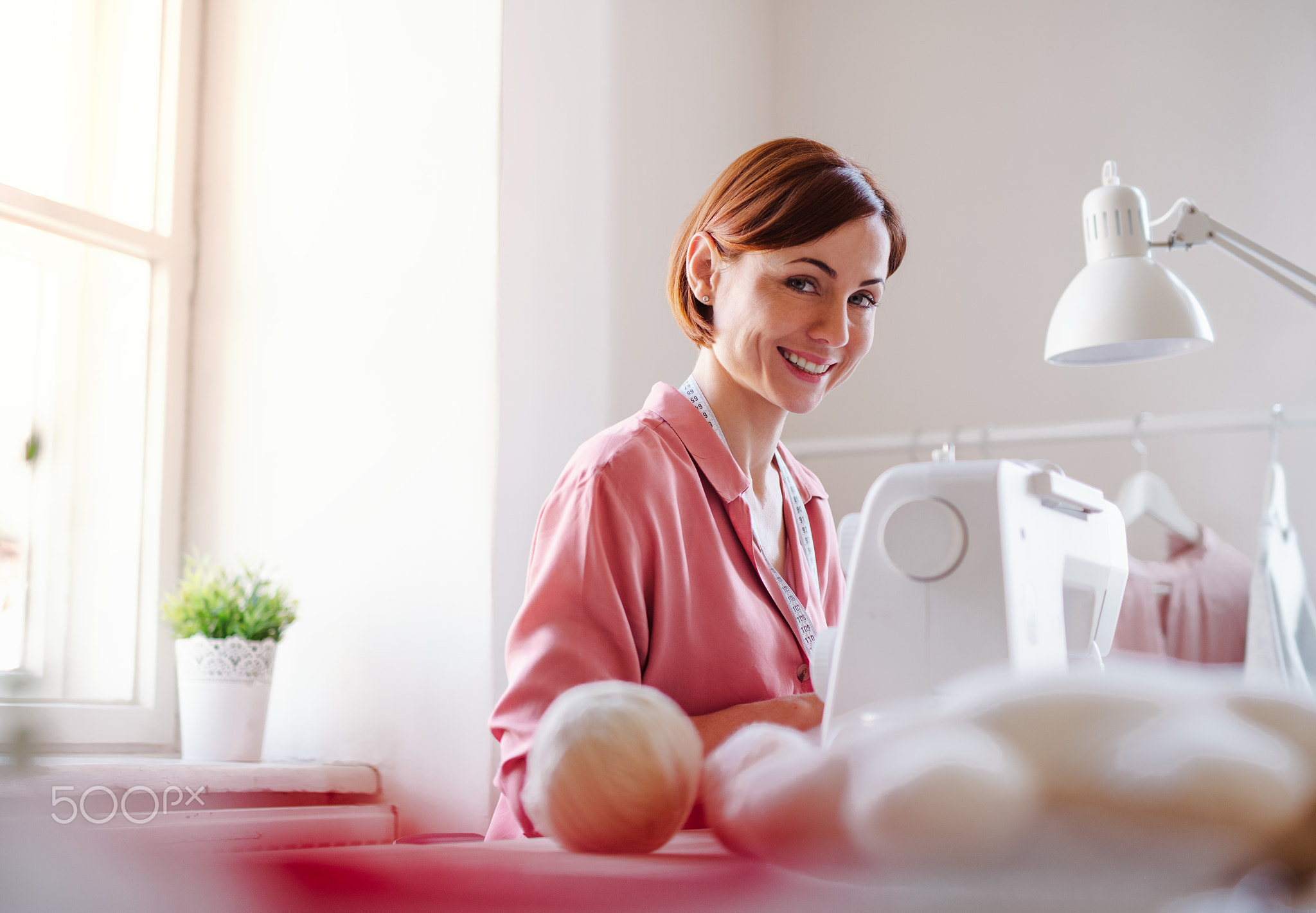 Young creative woman in a studio, working. A startup of tailoring business.