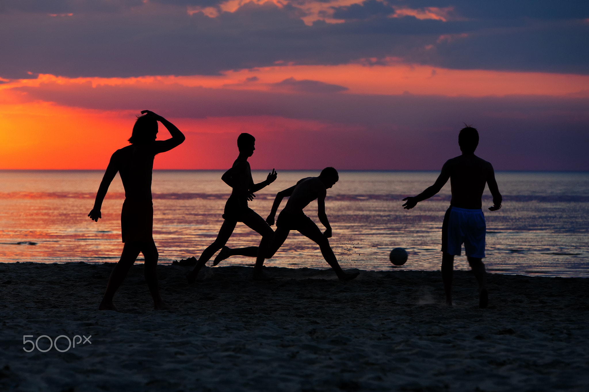 Silhouettes of footballers on the sunset