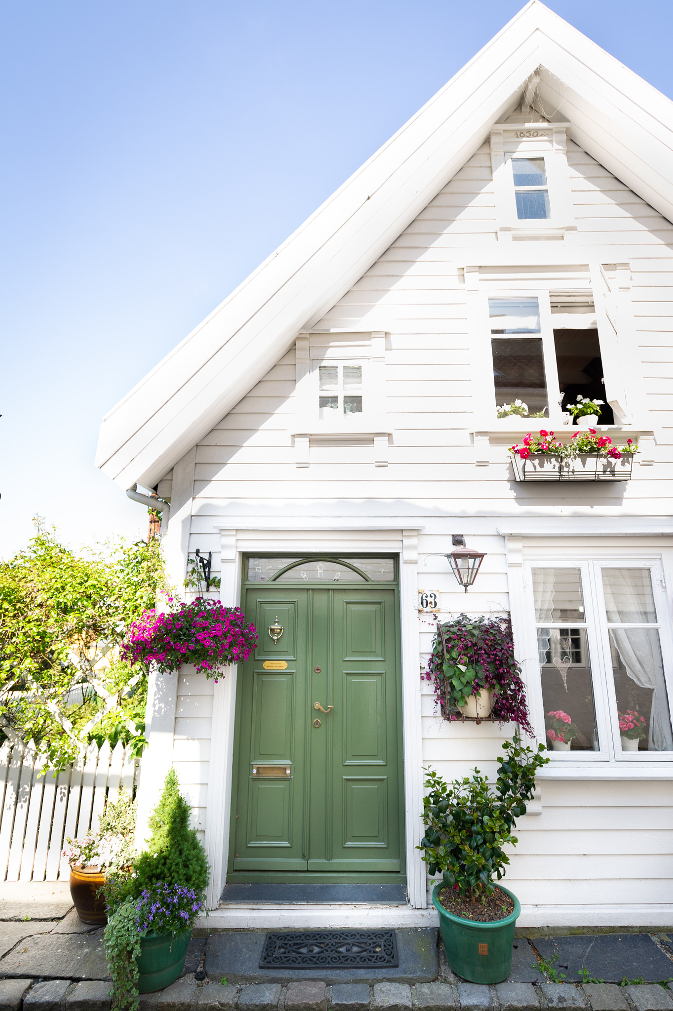 Old White Wooden House In Summer With Green Door