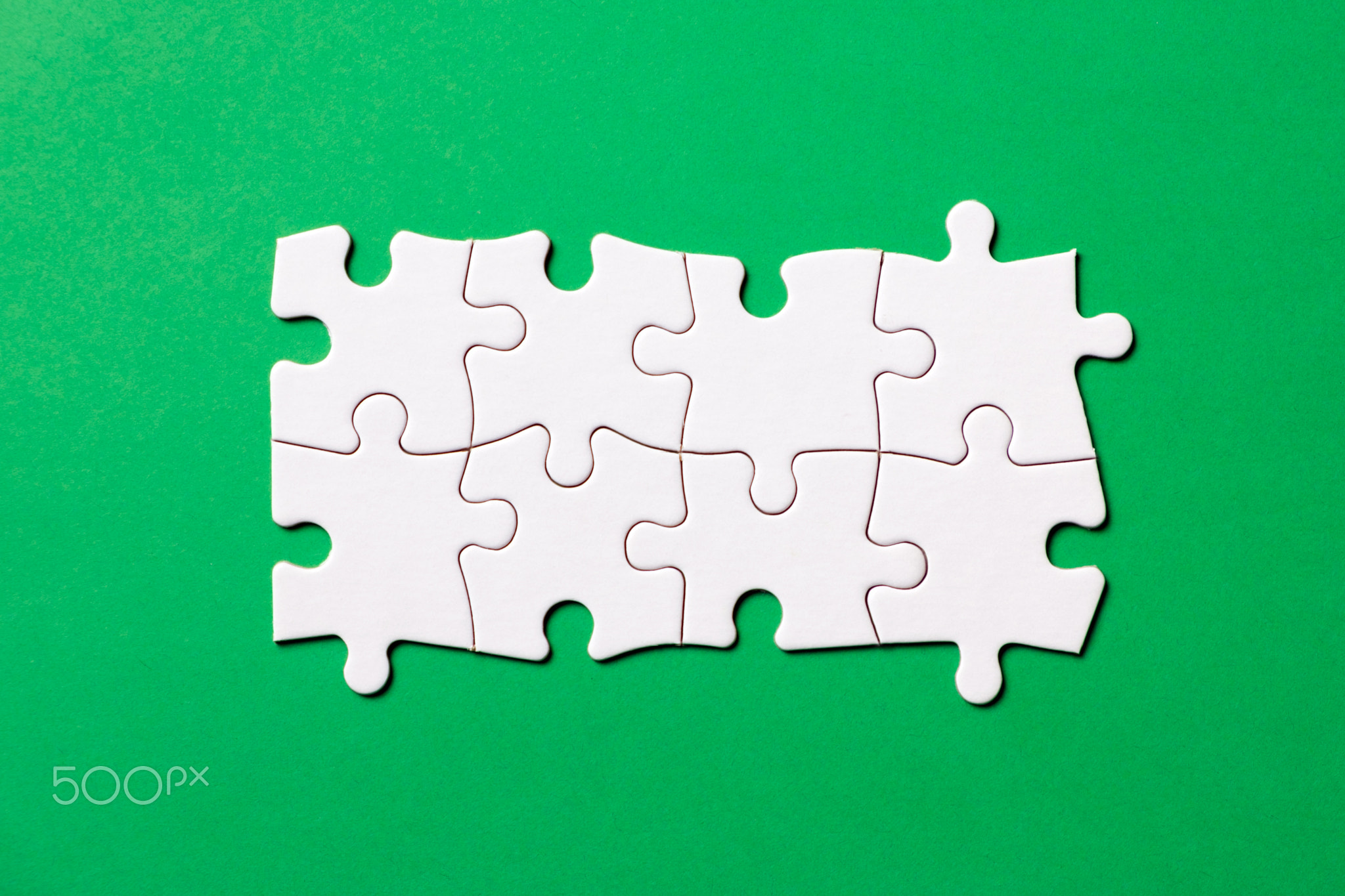 Eight pieces white jigsaw puzzle on green background for business presentation