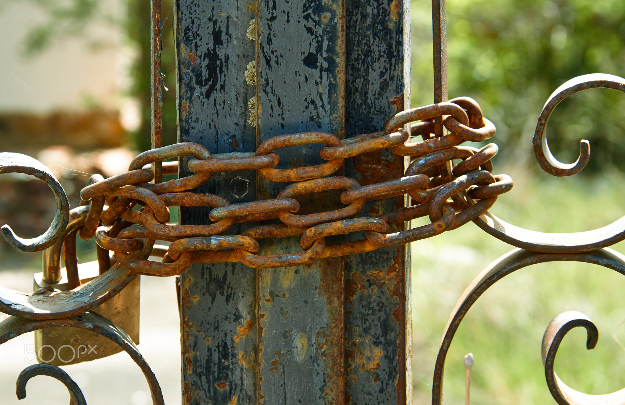Different images of closed field fence with rusty chain