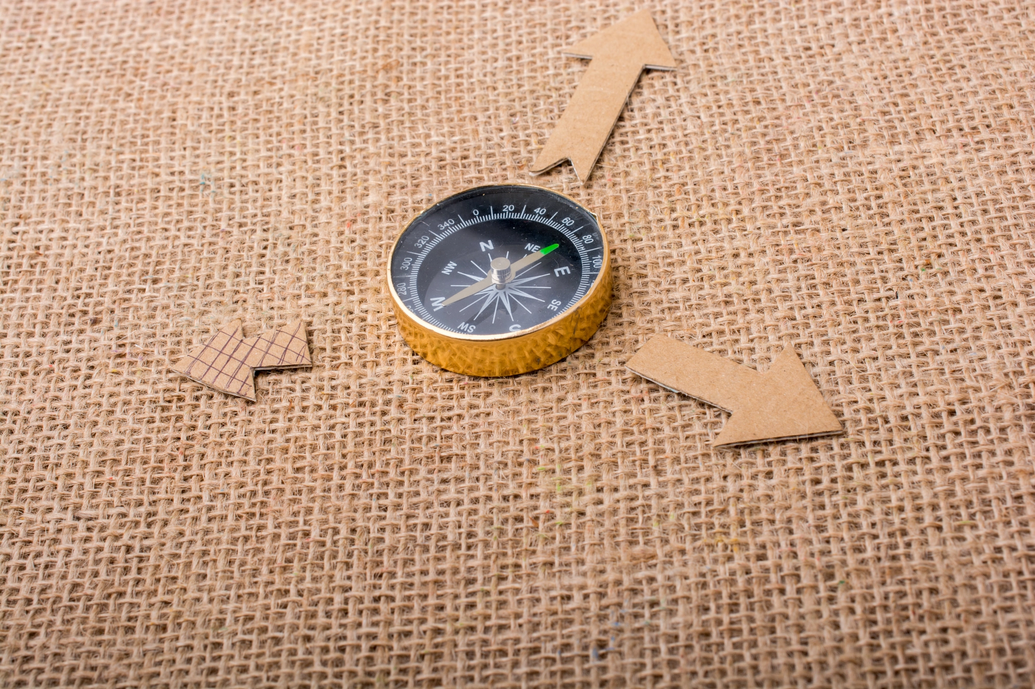 Compass and  paper arrow on a canvas