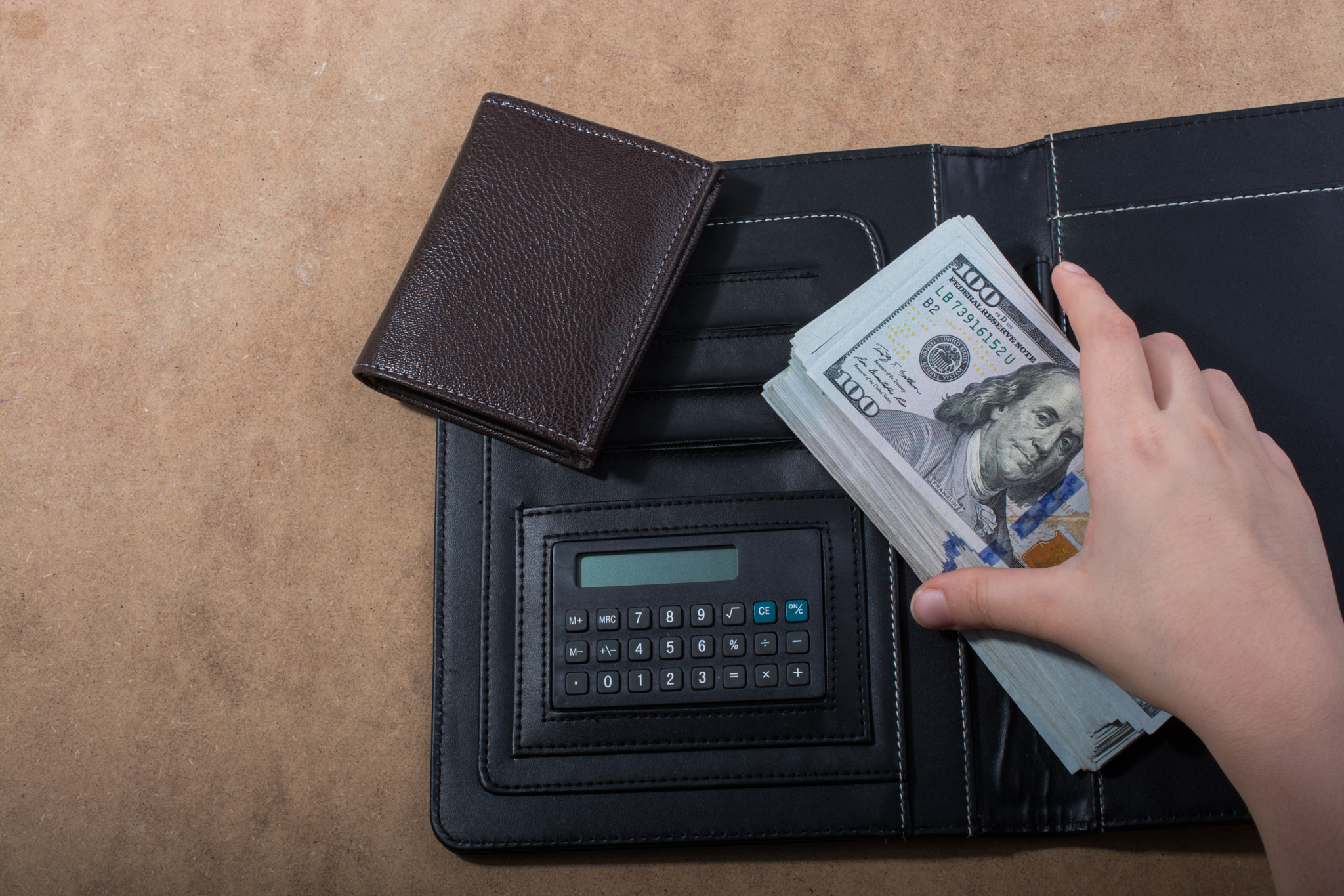 Hand holding American dollar isolated on wooden background