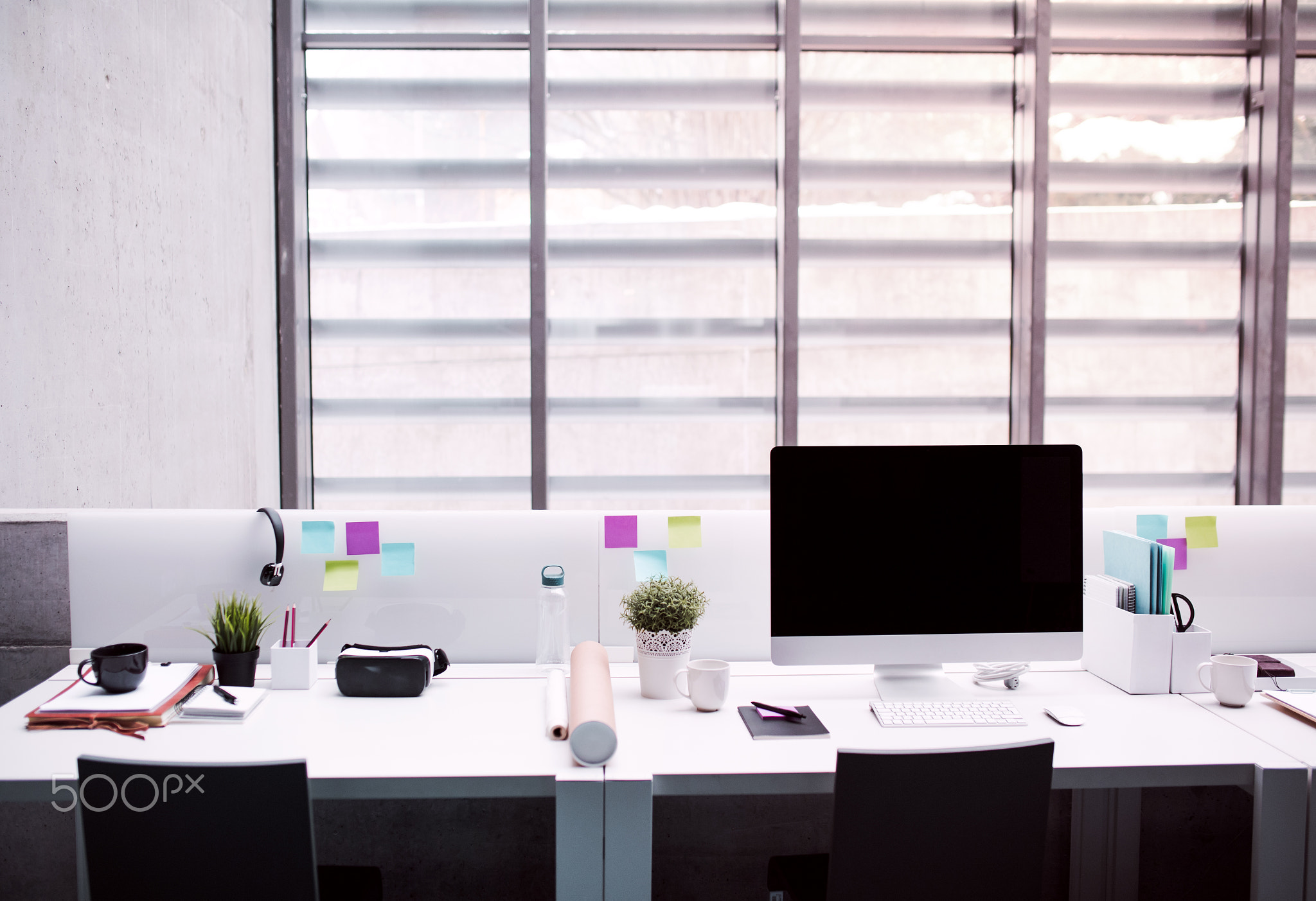 Desk with computer in interior of modern spacious office.