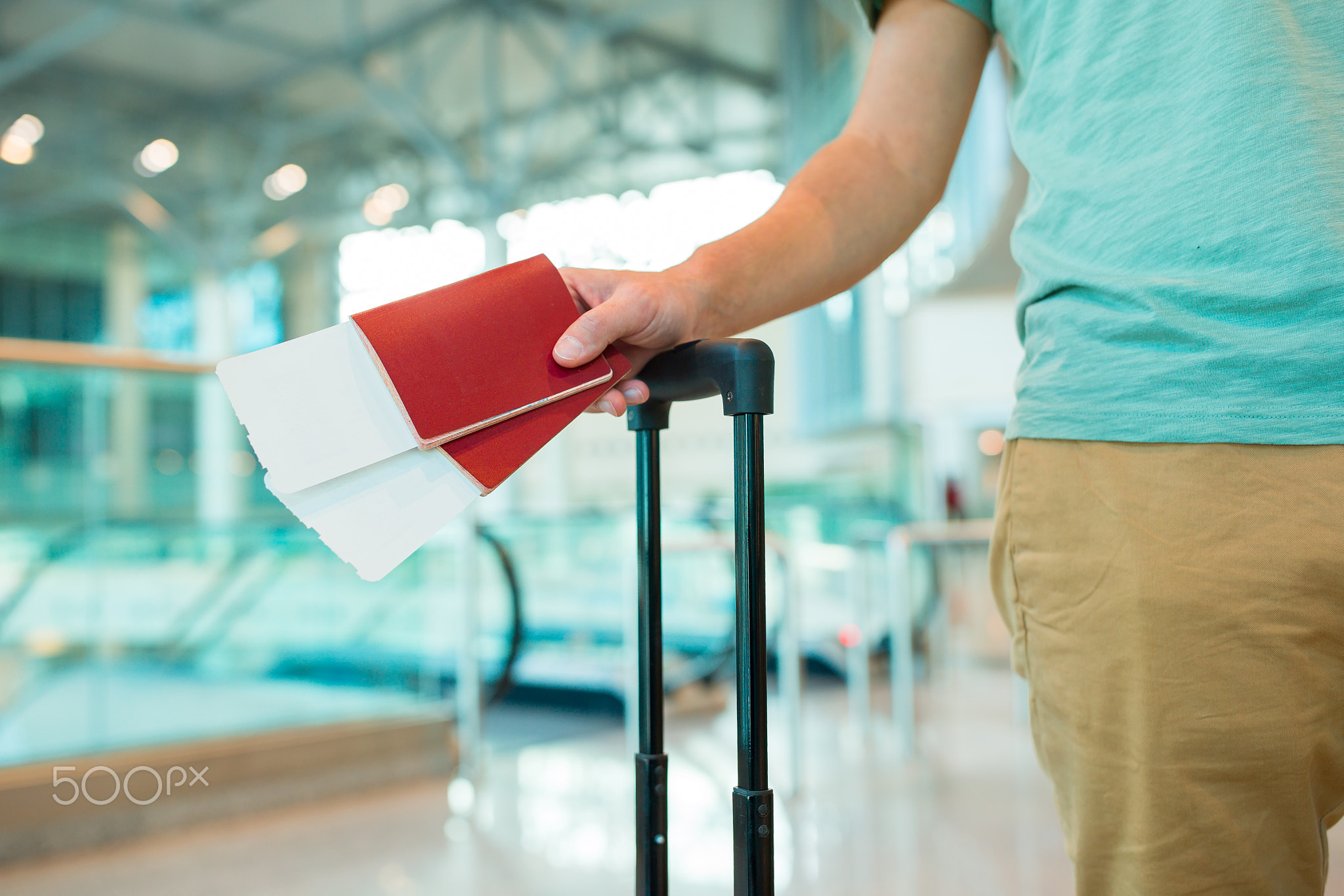 Close-up of passports and boarding pass in male hands at airport