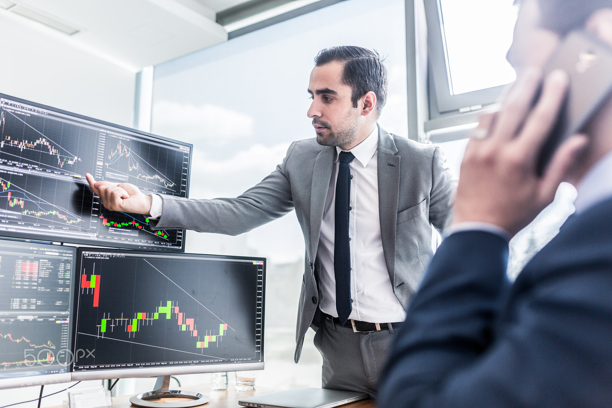 Stock brokers looking at computer screens, trading online.