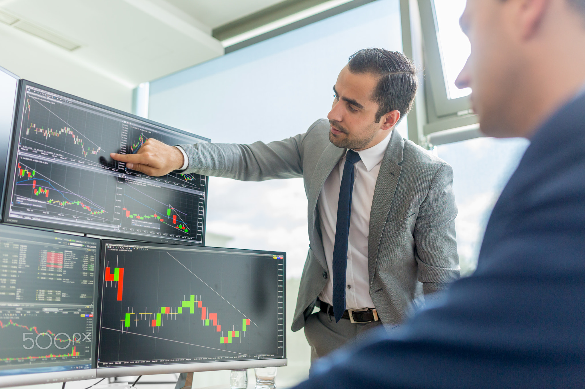 Stock brokers looking at computer screens, trading online.