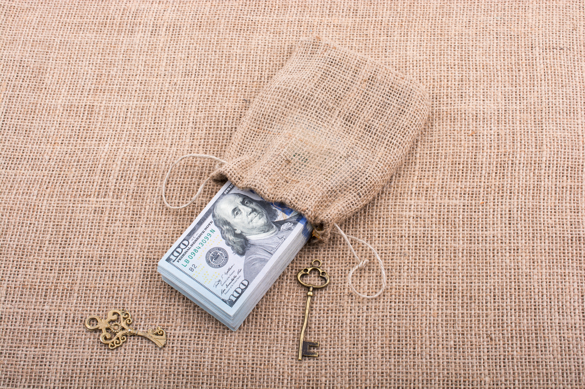 Retro key and bundle of US dollar in a sack