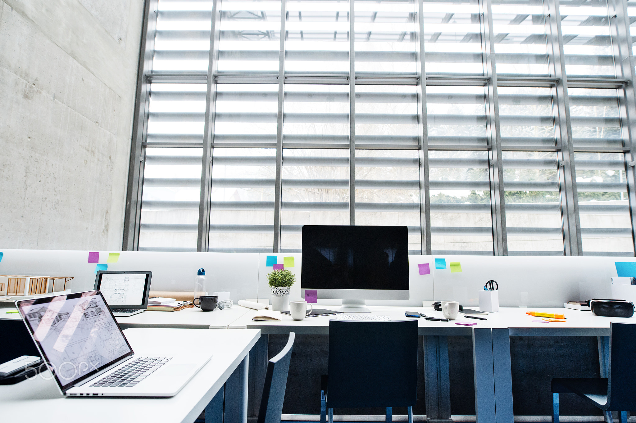 An interior of desks with computer in modern spacious office.
